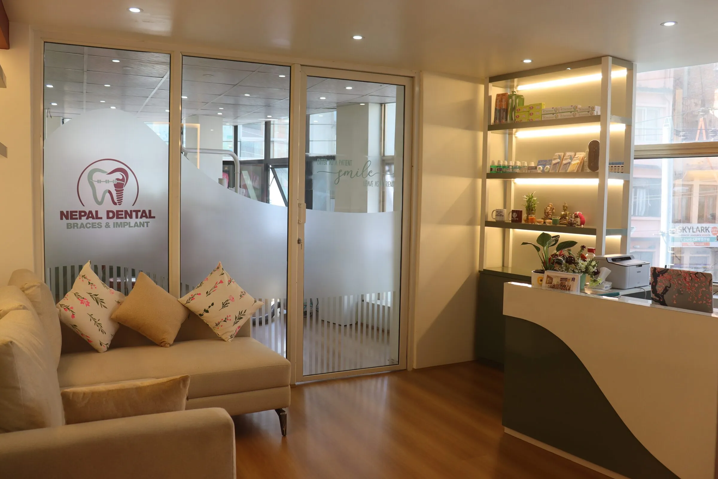 Reception and lounge with soft sofas and the clinic logo on frosted glass